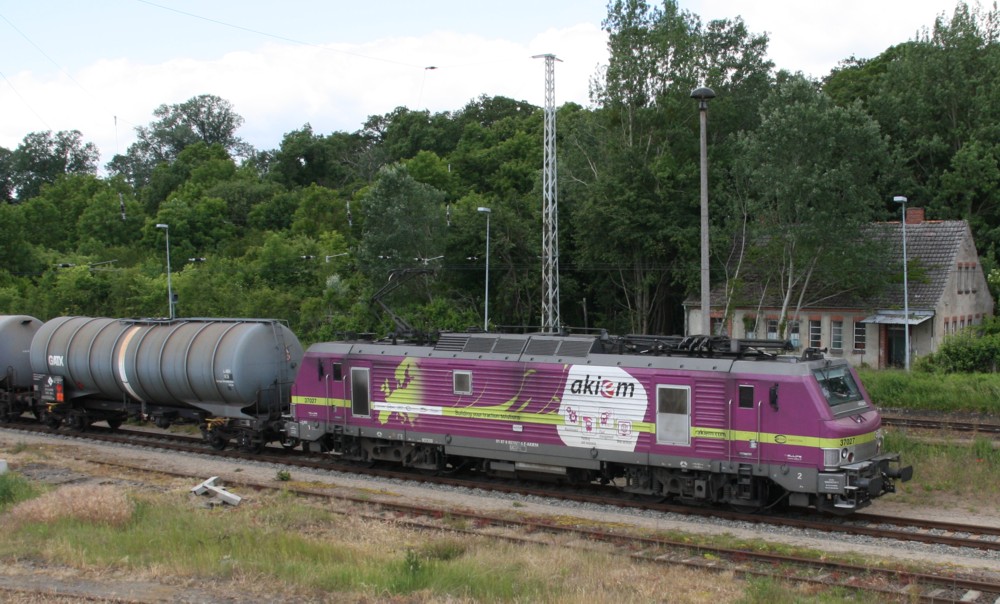 5.6.12 Passow. Akiem 37027 mit Kesselzug rollt langsam ihrem Ziel Stendell zu. Loks dieser Sorte in silberner Farbgebung standen schon fter in Angermnde vor dem neuen / alten Gterwageninstandsetzungswerk fr Kesselwagen (schlecht zu fotografieren - siehe Beitag Lokalzeitung: http://www.moz.de/heimat/lokalredaktionen/uckermark/artikel9/dg/0/1/979439/). 
Das ist allerdings die erste vor einem Zug, die mir vor die Linse kam.