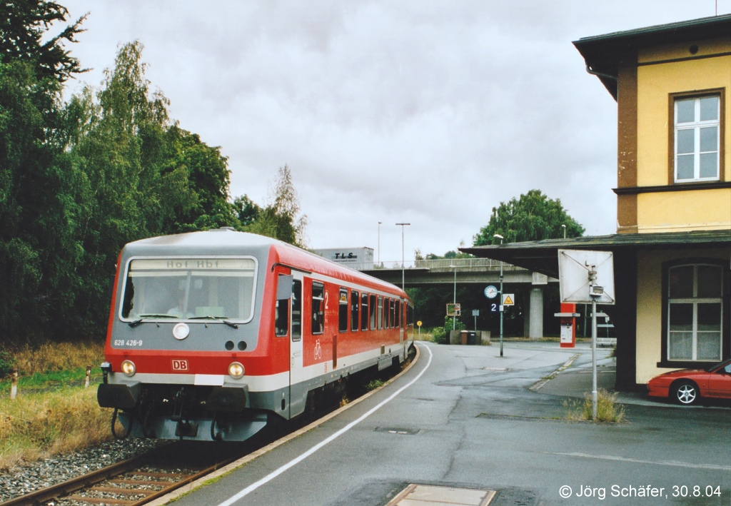 628 426 hlt als RB von Selb nach Hof in Oberkotzau auf Gleis 2. Rechts ist das Empfangsgebude noch mit Vordach zu sehen. (30.8.04)

