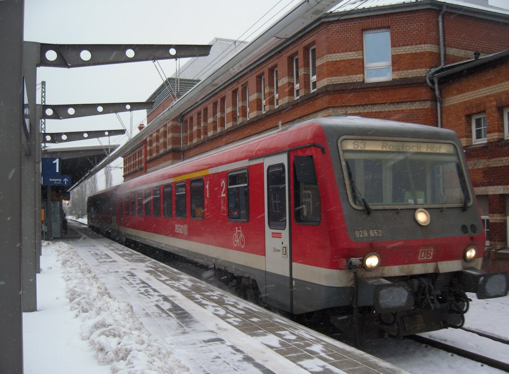 628 952 verlsst als S-Bahnlinie S3 den Rostocker Hbf in Richtung Seehafen Nord. Im Hintergrund das Empfangsgebude.
17.01.10