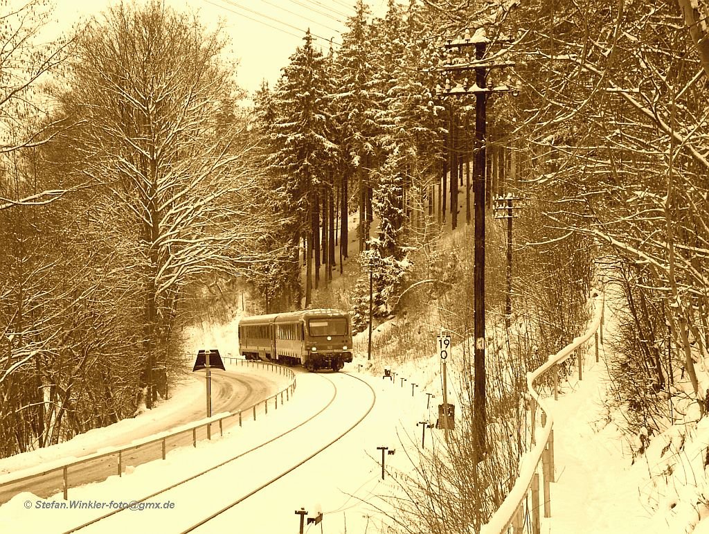 628238 kommt von Bad Steben her und wird gleich den Bahnhof Naila erreichen. Die winterliche Stimmung am 11.01.2010 reizte mich, dieses Motiv hier mal  auf alt  zu zeigen. Den früher mit 798, der bis 1993 hier fuhr, sah es auch nicht anders aus. Nur das Geländer rechts, das hatte damals noch einen hölzernen Handlauf..... Hoffe es gefällt.