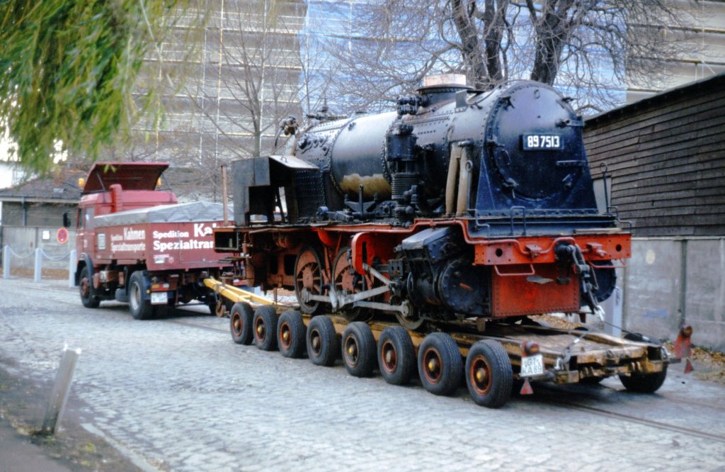 89 7513 Abtransport aus Berlin, hier teildemontiert auf dem Tieflader Nov. 1986. Die lange als Spielplatzlok aufgestellte Lok kam auf die Berliner Insel Eiswerder, wo sie im Freiem. aber �berdacht untergestellt wurde. Nachdem man die Lok durch Abbau von Teilen zum Transport vorbereitet hatte, erfolgte Verladung und Abtransport. Der letzte Standort war Eiswerder, stand rechts hinter der mit abgebildeten Wand. Auf dem Weg in eine bessere Zukunft ...