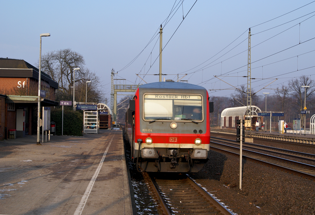 928 654 als RE nach von Hamburg Hbf nach Rostock Hbf am 27.02.2011 in Schwarzenbek.In Schwerin Hbf stand die eigentliche Garnitur (120+Dostos) fr die Weiterfahrt nach Rostock bereit.