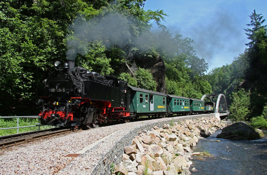 99 1734-5 zieht am 22.05.2011 ihren Personenzug durch den romantischen Rabenauer Grund. Hier in Hhe der neu entstandenen Stahlbogenbrcke oberhalb des Bahnhofs Rabenau. 