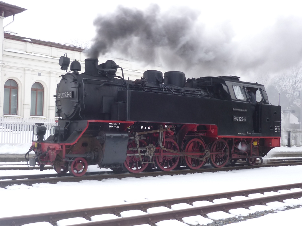 99 2323-6 wartet an einem trben Grndonnerstag vor dem Doberaner Bahnhof. Kurz darauf wird die Weiche gestellt und die O&K-Lok kann sich vor ihre Feierabendleistung nach Khlungsborn West setzen.
Bad Doberan, Grndonnerstag 2013.