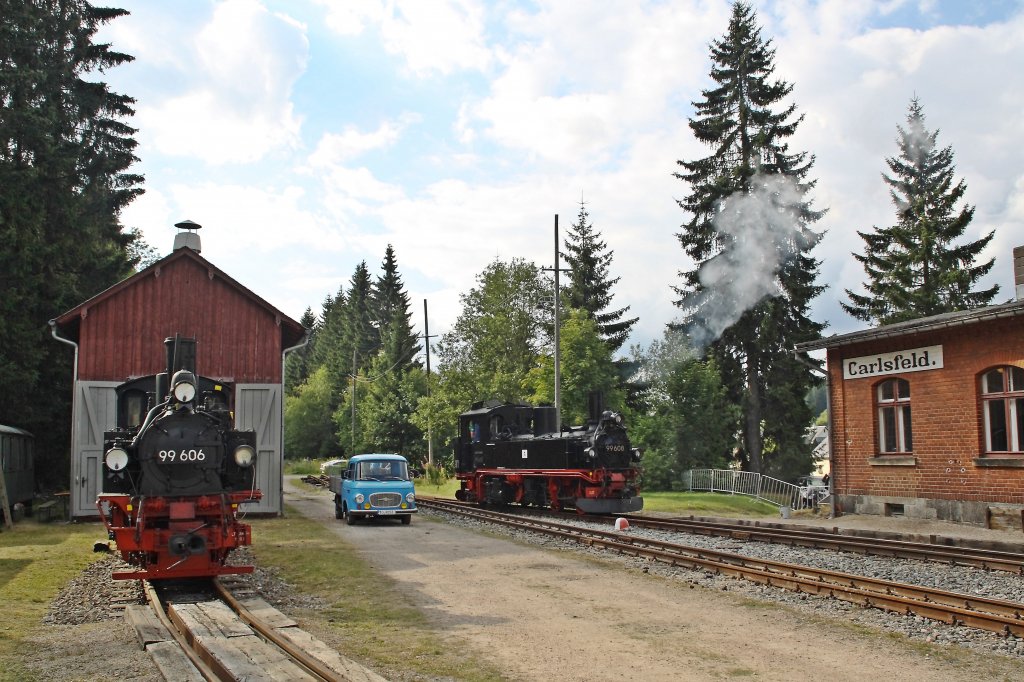 99 606 (VSSB) und 99 608 (SDG) und ein Barkas B1000 am 12.08.2012 im Bahnhof Carlsfeld.