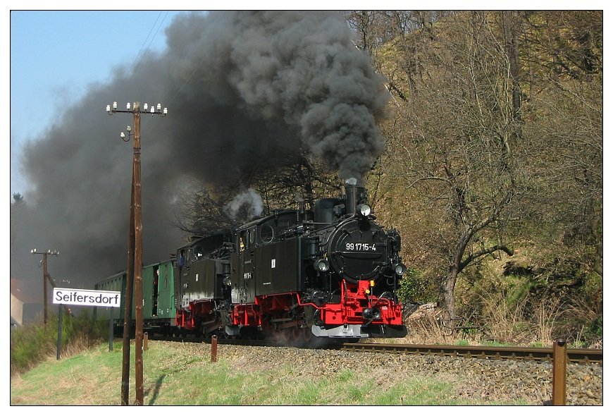 99 713 als Zuglok und 99 715 als Vorspann ziehen am 20.04.2003 gemeinsam einen Zug von Seifersdorf nach Dippoldiswalde und haben hier soeben den Bahnhof Seifersdorf verlassen. 99 715 hatte hier nach vieljhriger Abstellzeit nach erfolgter HU wieder ihre ersten Betriebseinstze. Meines Wissens haben beide VI K-Lokomotiven danach jedoch nie wieder gemeinsam einen Zug gezogen!