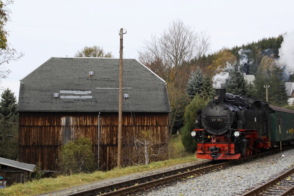 99 786 passiert am 22.10.2010 die Scheune in der Bahnhofseinfahrt von Neudorf. 

