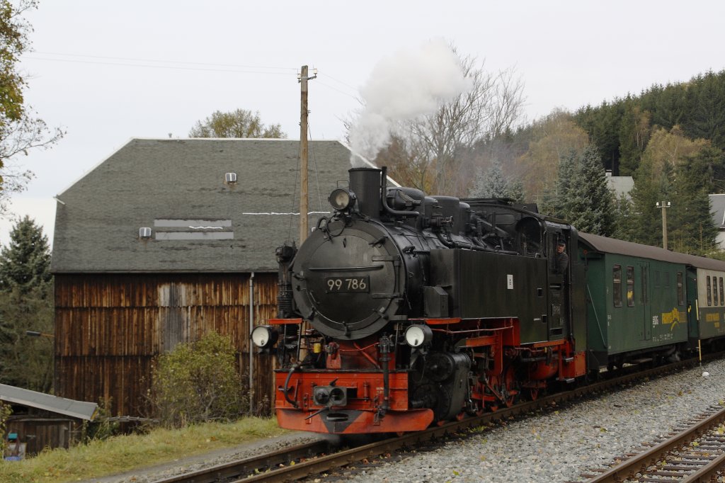 99 786 passiert am 22.10.2010 die Scheune in der Bahnhofseinfahrt von Neudorf. 

