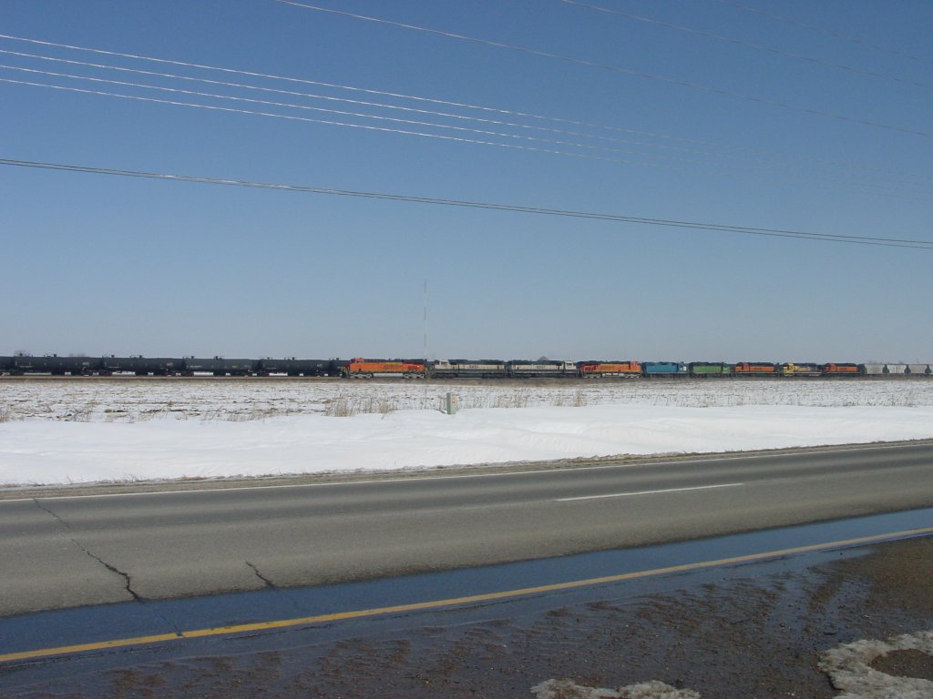 A westbound train with 9 BNSF locomotives builds up speed after climbing out of the Mississippi River valley. 3 Mar 2010.