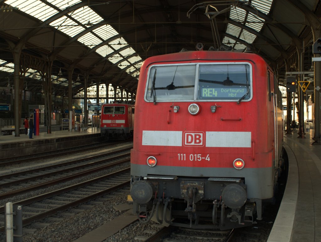 Aachen Hbf am 20.11.2010. Auf Gleis 3 steht 111 015-4, sie schiebt gleich den RE4 nach Dortmund. Von Gleis 6 zieht 111 011-3 den RE 9 nach Siegen.