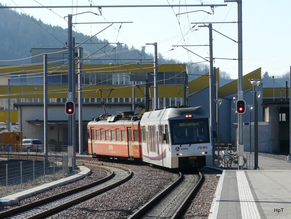 AAR - Gegenlichtaufname Regio nach Schftland mit Steuerwagen ABt 59 und Triebwagen Be 4/4 19 bei der einfahrt in den Bahnhof Suhr am 05.02.2011

