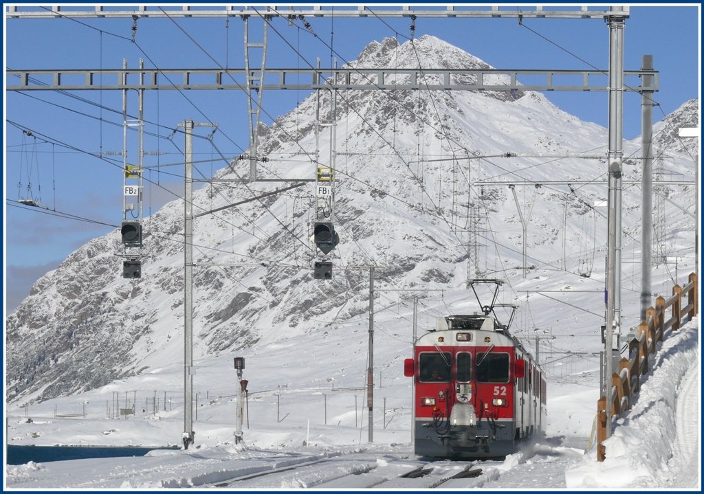 ABe 4/4 III 52  Brusio  und 56  Corviglia  erreichen mit R1621 die Station Ospizio Bernina 2253m. Der Piz Albris 3165m bildet die Kulisse. (11.11.2009)