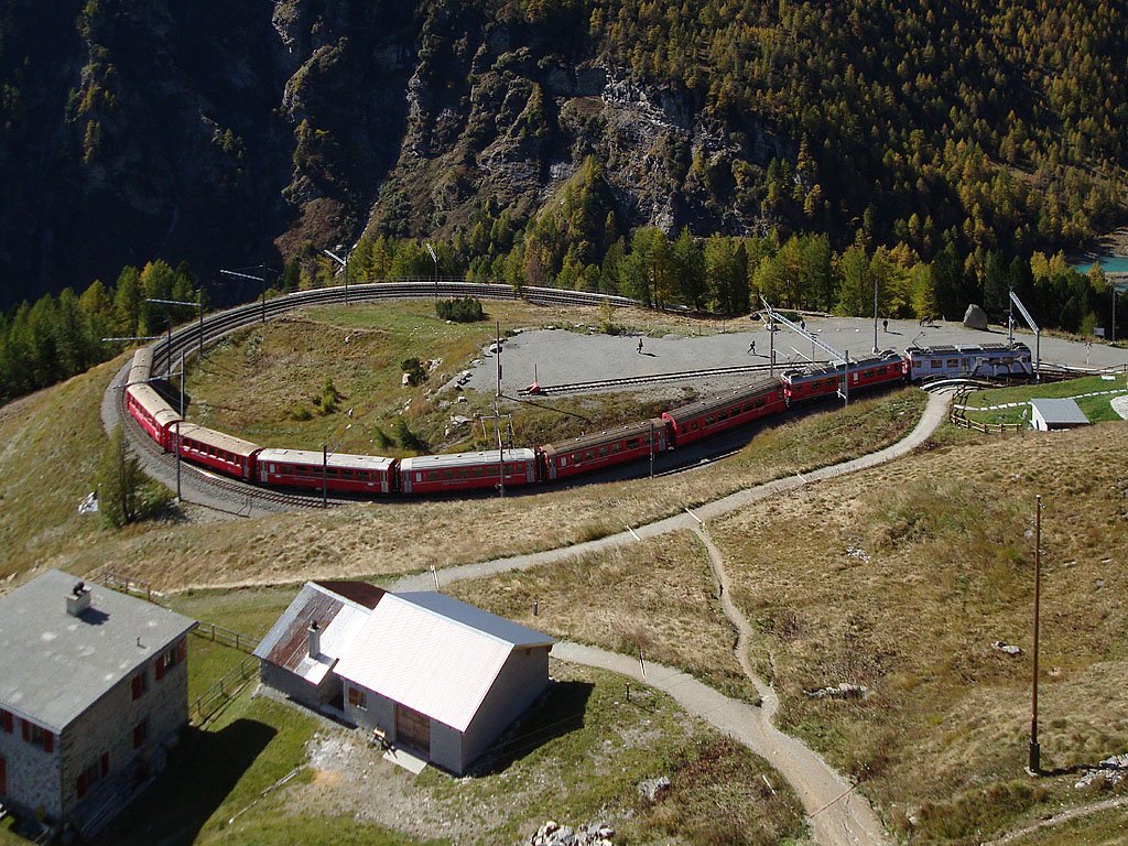 ABe 4/4 III Nr. 51 im UNESCO-Weltkulturerbe-Kleid + weitere mit neutraler Lackierung verlassen mit ihrem Zug die 180-Kehre kurz vor dem Bahnhof Alp Grm, 11. Okt. 2009, 12:17