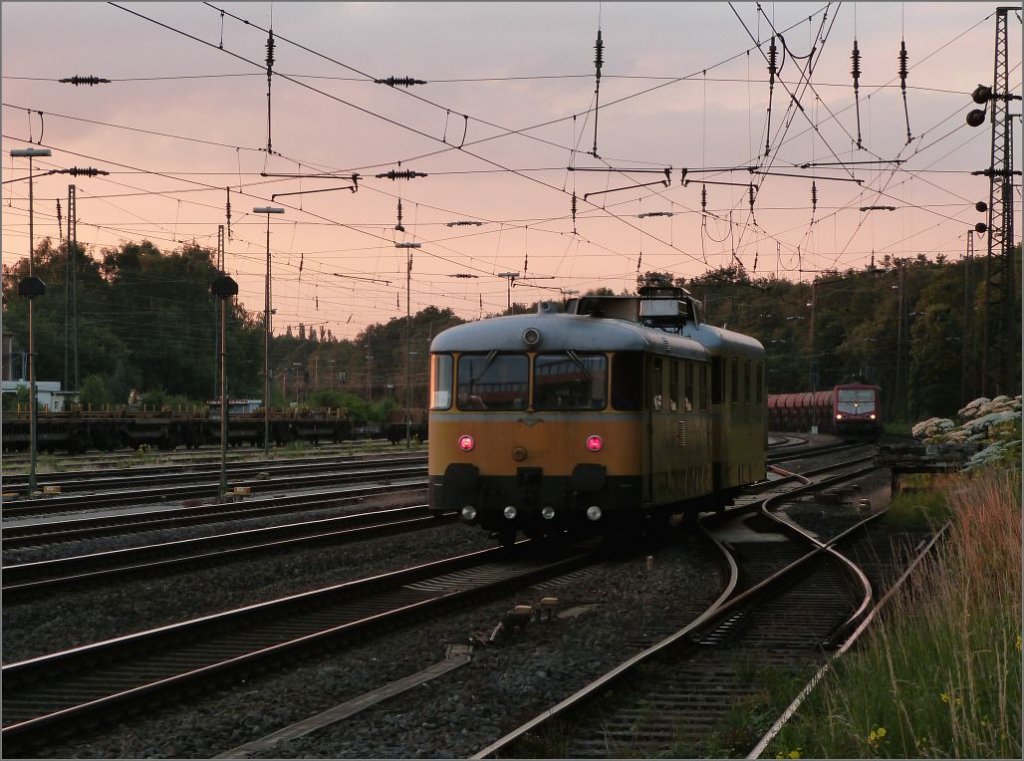 Abendstimmung in Duisburg Wedau im Juli 2012. Ein Gleismesszug trifft auf eine 
155 mit Gterfracht am Haken.