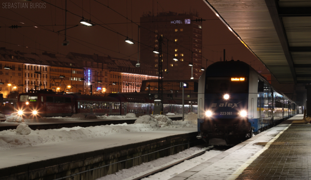 Abendszene aus Mnchen Hbf: Whrend der Alex, gefhrt von 223 061, in Krze um 19:19 seine Fahrt nach Lindau antreten wird, wartet im Hintergrund noch eine 111 mit ihrer Regionalbahn nach Mittenwald, welche erst um 19:32 abfahren wird (15.02.2013)