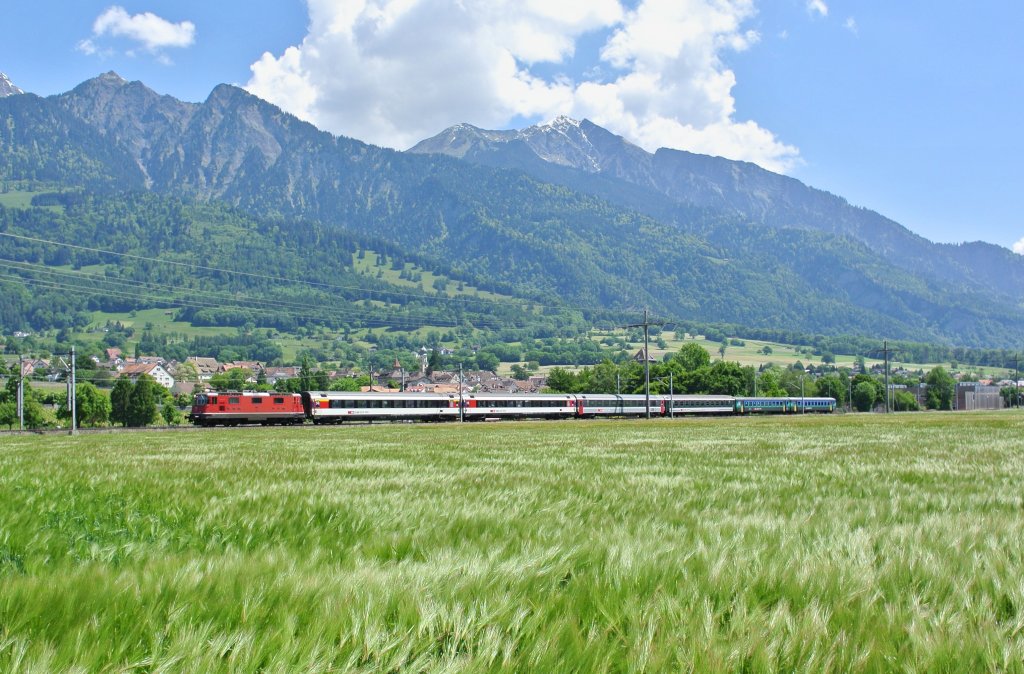 Abschied des lokbespannten Rheintal Express: RE REX 3828 mit der Re 4/4 II 11157 bei Maienfeld, 07.06.2013.
