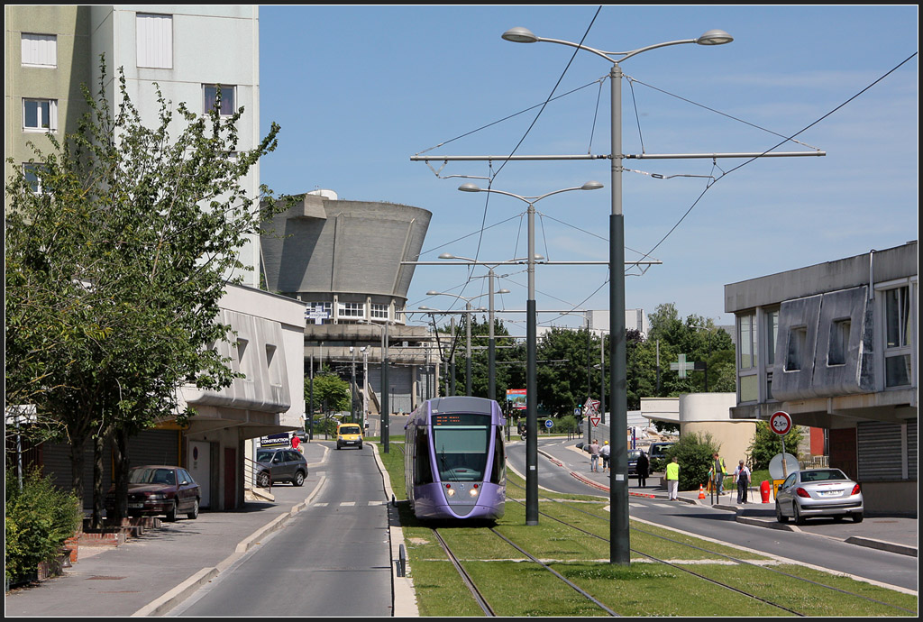 Abzweig der Linie B - 

Nahe dem südlichen Endpunkt der Linie A zweigt eine Strecke zum TGV-Bahnhof  Care Champagne TGV  ab. Dafür wurde eine zweite Linie (B) eingerichtet, die den in Bezannes liegenden TGV-Bahnhof mit dem Hauptbahnhof von Reims verbindet. Hier ein Blick von der Haltestelle  Léon Blum  in Richtung dem Gleisdreiceck, mittels dem der Abzweig an die Strecke der Linie A angeschlossen ist. Hier wird auf Rasenbahnkörper eine Hochhaussiedlung durchfahren. Uns ist nicht ganz klar geworden, was der suppenschüsselähnliche Bau im Hintergrund beinhaltet, vielleicht ein Wasserbehälter? 

24.07.2012 (M)