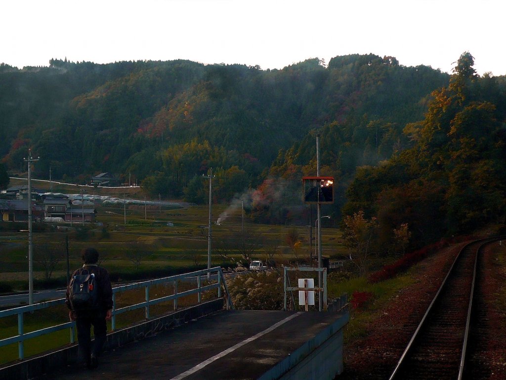 Akechi-Bahn - Heimfahrt: Nach Abfahrt in Akechi ist erst einmal Pass Nr.4 zu bewltigen; hier im Aufstieg in Noshi. Bauersleute kehren heim, whrend die Frontlichter des Triebwagens 11 im verbeulten Spiegel leuchten. 5.November 2008.  