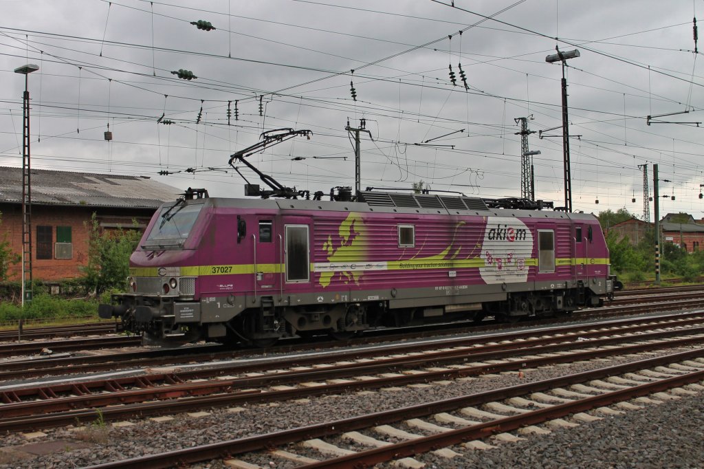 Akiem BB 37027 wartet am 22.05.2013 im Rangierbahnhof von Worms auf die Weiterfahrt Richtung Mannheim. Hier sieht man die Lila Sch�nheit von der Seite.