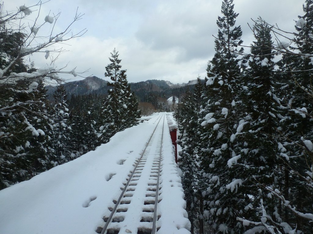 Akita Nairiku-Bahn, die 1963 erffnete Verlngerung des Nordabschnitts: Typisch Lokalbahnatmosphre - bei der Ueberquerung der Schluchten verlangsamt der Wagenfhrer die Geschwindigkeit auf Schritttempo und fordert die Fahrgste auf, die schne Natur zu geniessen. Abstieg von Okashinai nach Kayakusa, 14.Februar 2013, aus Wagen 8805.  