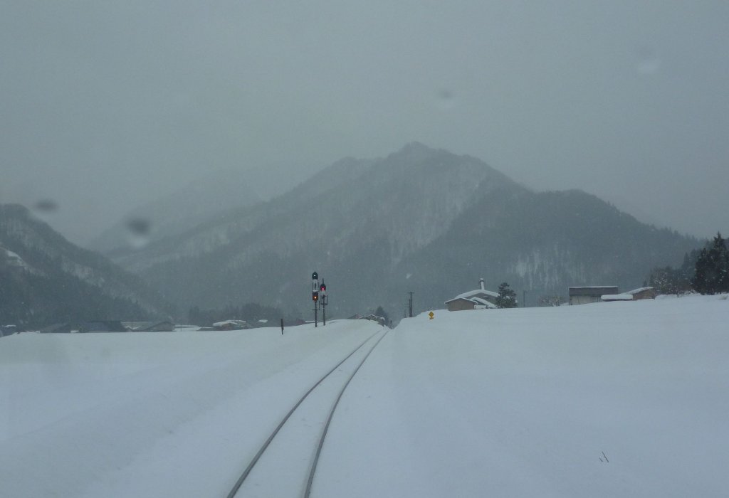 Akita Nairiku-Bahn, die 1963 erffnete Verlngerung des Nordabschnitts: Die nchste Station kndigt sich dem Triebwagen 8805 durch drei Signallichter (grn-gelb-rot) an, die in der dsteren Stimmung geradezu surreal wirken. Hitachinai, 14.Februar 2013. 