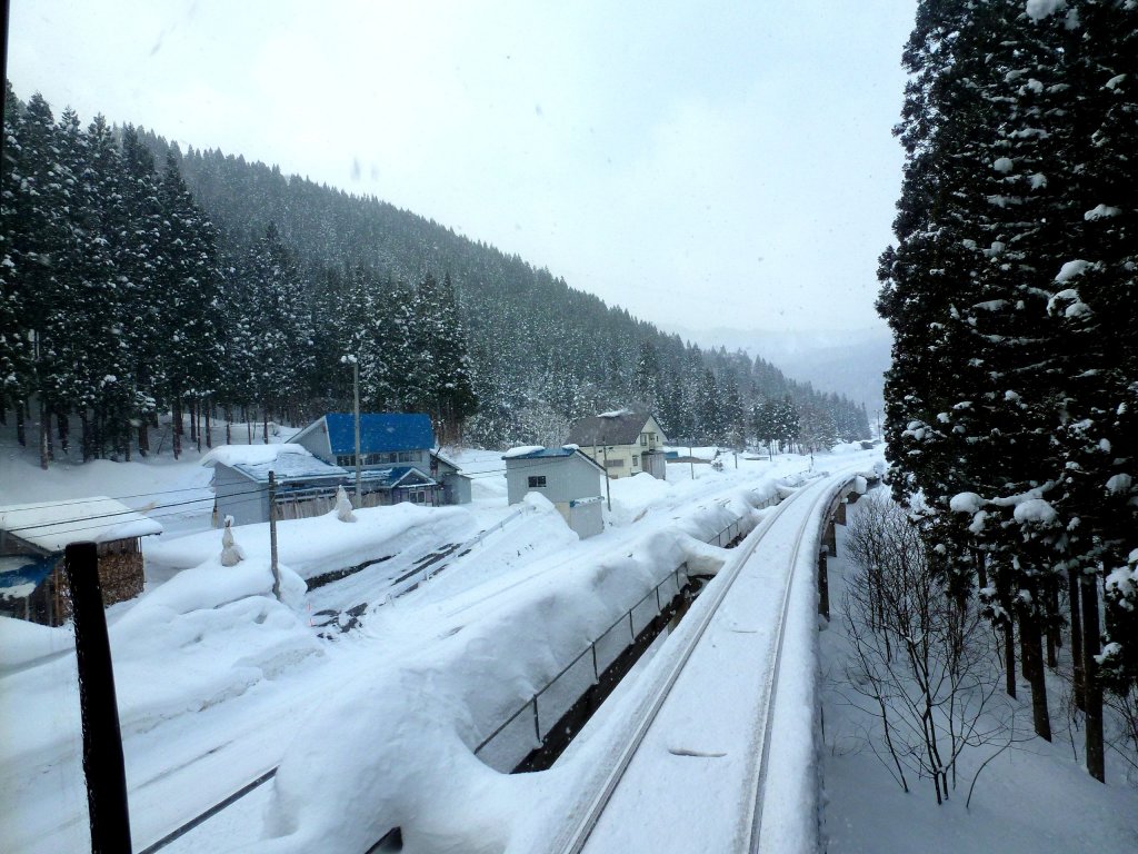 Akita Nairiku Bahn, auf dem neuen Mittelteil (1989), Abstieg vom Scheiteltunnel nach Norden: Einfahrt in das tief verschneite Hitachinai, 14.Februar 2013. 