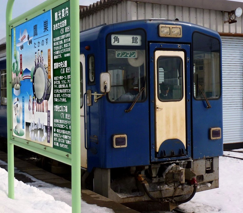 Akita Nairiku-Bahn, Nordabschnitt: An der nrdlichen Endstation Takanosu steht Wagen 8805 vor einer grossen Werbetafel fr die touristischen Attraktionen der Gegend, allen voran die Trommelfeste mit den riesengrossen Instrumenten. 14.Februar 2013. 