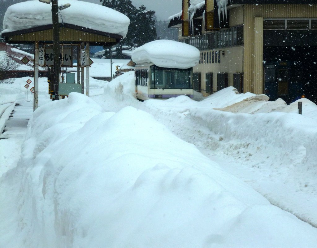 Akita Nairiku Bahn, die Touristik-Schnellzugstriebwagen: Bei der Einfahrt zum Bahnsteig Aniai mit seinen riesigen Schneehaufen kommt Wagen 8903 in Sicht, wie er langsam von Schneemassen erdrckt wird. 14.Februar 2013. 