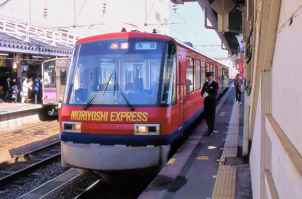 Akita Nairiku Bahn, die Touristik-Schnellzugstriebwagen: Lange ist es her - einst holten die Schnellz�ge der Akita Nairiku-Bahn ihre Fahrg�ste in der 180 000-Einwohnerstadt Hirosaki ab und fuhren dann zuerst 62 km auf der JR-Strecke, bis sie ihr eigenes Netz in Takanosu erreichten. Sowohl der Regeleinsatz der Touristikz�ge, wie auch die Fahrten �ber die JR, sind heute des Defizits wegen undenkbar, und die Touristen m�ssen f�r die schnellere Verbindung mit gew�hnlichen Lokaltriebwagen zufrieden sein. Bild: Wagen 8902 im JR-Bahnhof Hirosaki, 22.April 2003.  
