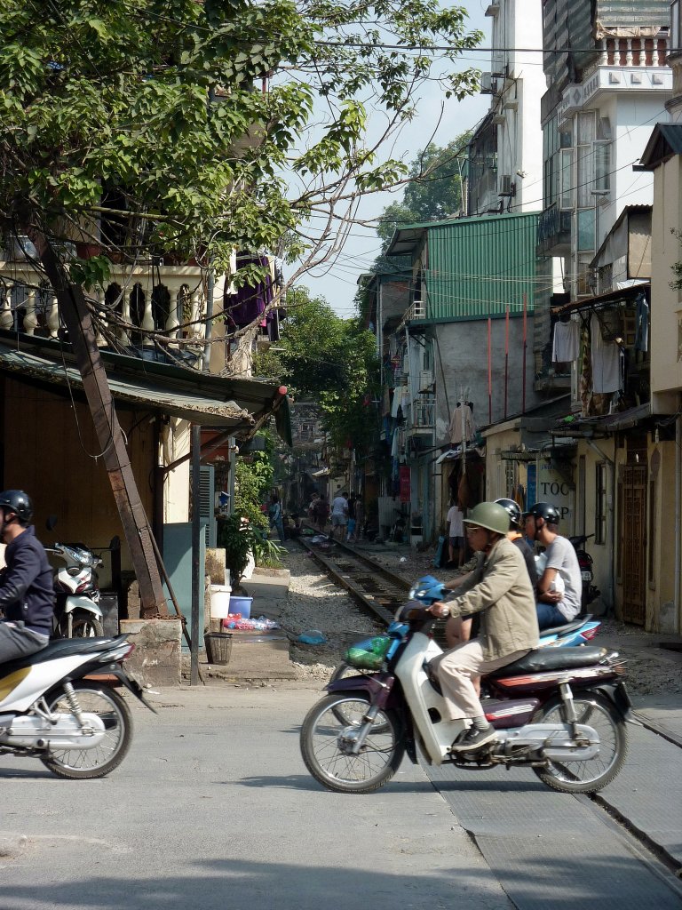 Allgegenwrtig in Vietnam sind die Motorroller. Hier berqueren am 15.12.2012 mehrere Scooter die Bahnstrecke von Hanoi in Richtung China.