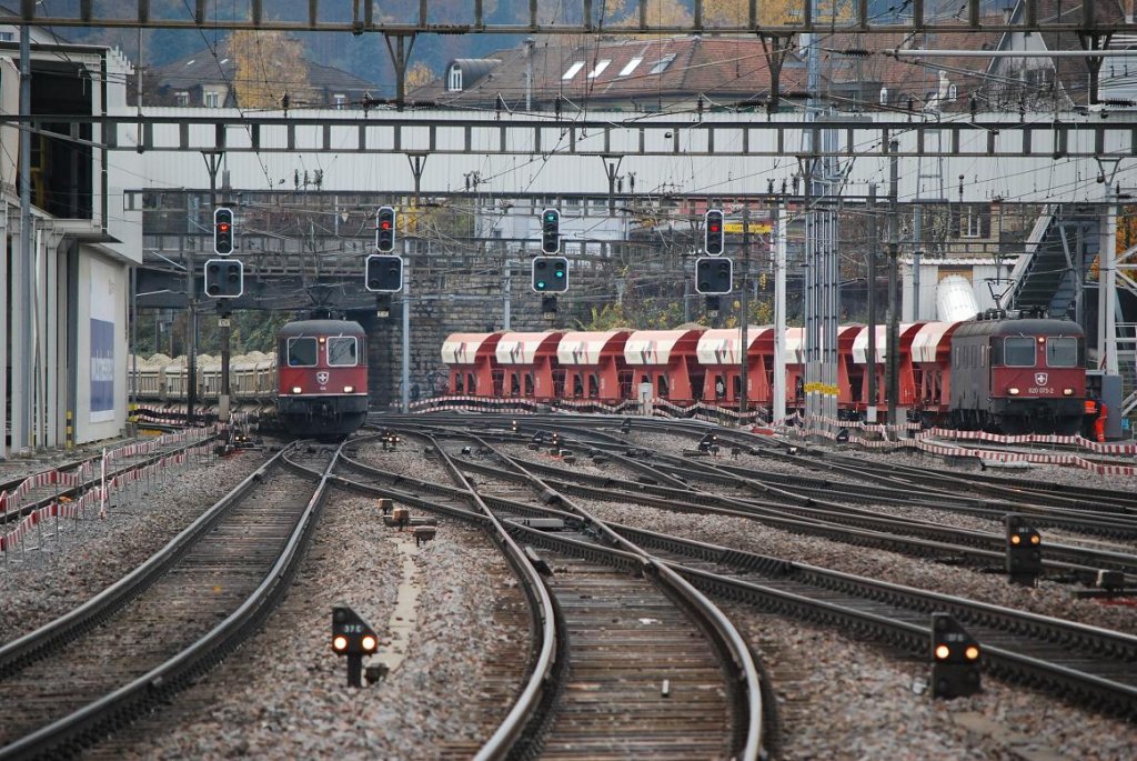 Alltag im Bahnhofsvorfeld Oerlikon: Am 16.11.09 rangiert Re 620 075-2 (Re 6/6 11675) im Cargokleid ihren Schttgutzug zur Entladung, whrend Re 6/6 11616 (UIC: Re 620 016-6) mit dem Schotterzug, welcher vorher noch auf dem Beladegleis links vom Bild stand, gleich den Bahnhof durchquert. Die 11616 trgt noch die komplett rote Lackierung und ihre Wappen. Sie gehrt zu den wenigen Ausnahmen mit zwei versciedenen Wappen an den Seiten (Illnau und Effretikon).