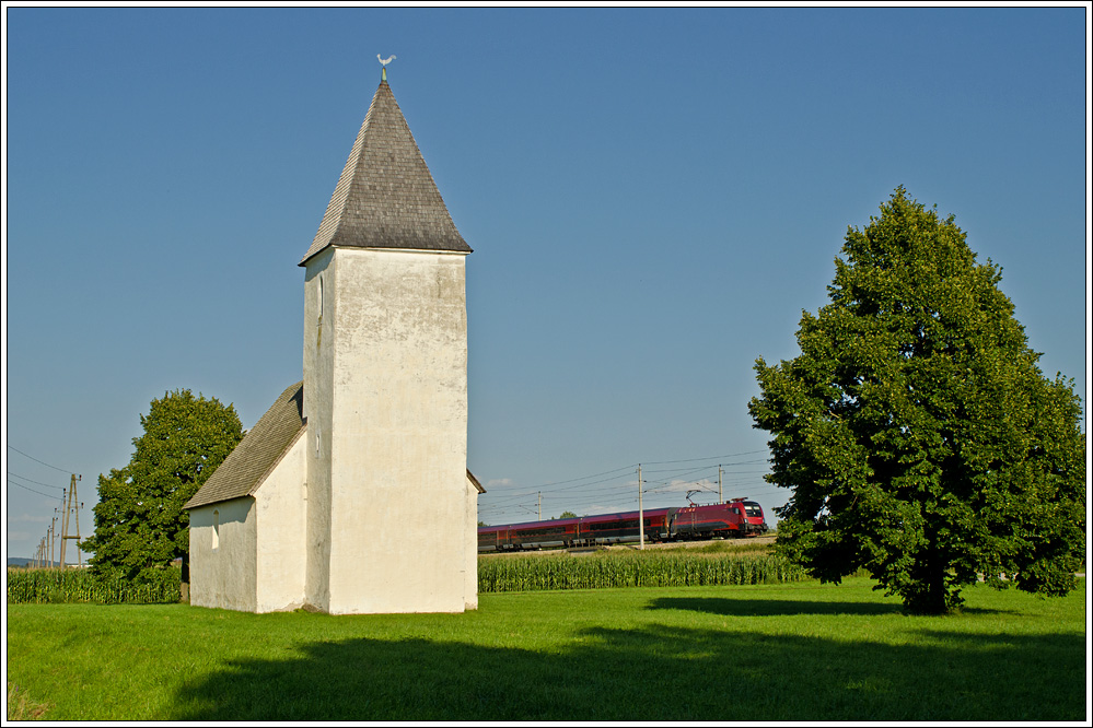 Alte Westbahn: ein RJ passiert das Martinikircherl von Matzendorf bei Kirchstetten, 13.8.2012. Das Motiv (auch mit anderen Zgen ;-)) ist eher in den Sommermonaten umsetzbar, da sonst das Licht nicht weit genug herberkommt, sonst auf den Hochnebel im Herbst warten.....