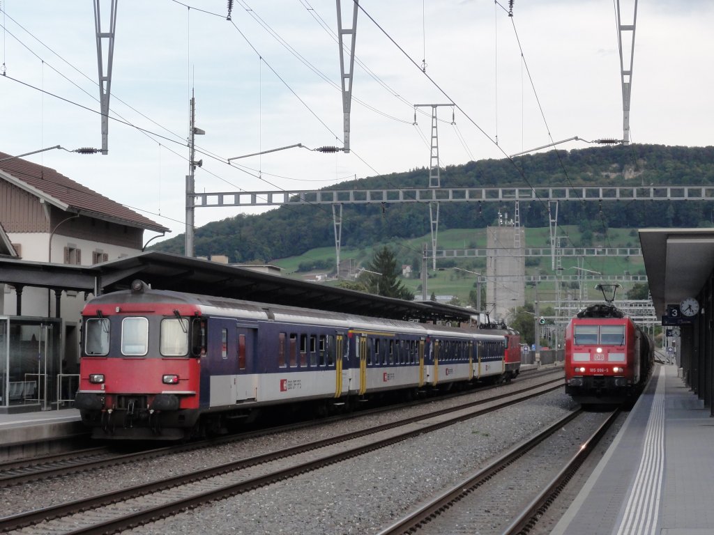 Altmetall-Zug mit Re 4/4 II und Einfahrt einer BR 185 mit Kesselzug am 01.09.2011 in Sissach.
