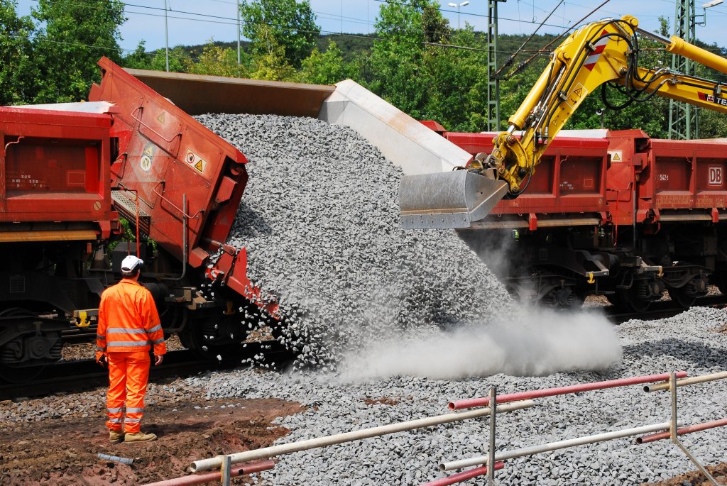 Am 01.08.2009 wurde im Brackweder Bahnhof an der Personenzugstrecke ein Weiche erneuert. Hier wird mit neuem Schotter das Gleisbett bereit gemacht. Der so halb sichtbare Bagger ist ein Liebherr-Bagger auf Schienenaufsatz, der auf dem gekappten Gleis bis an die Baustelle herangerollt war.
