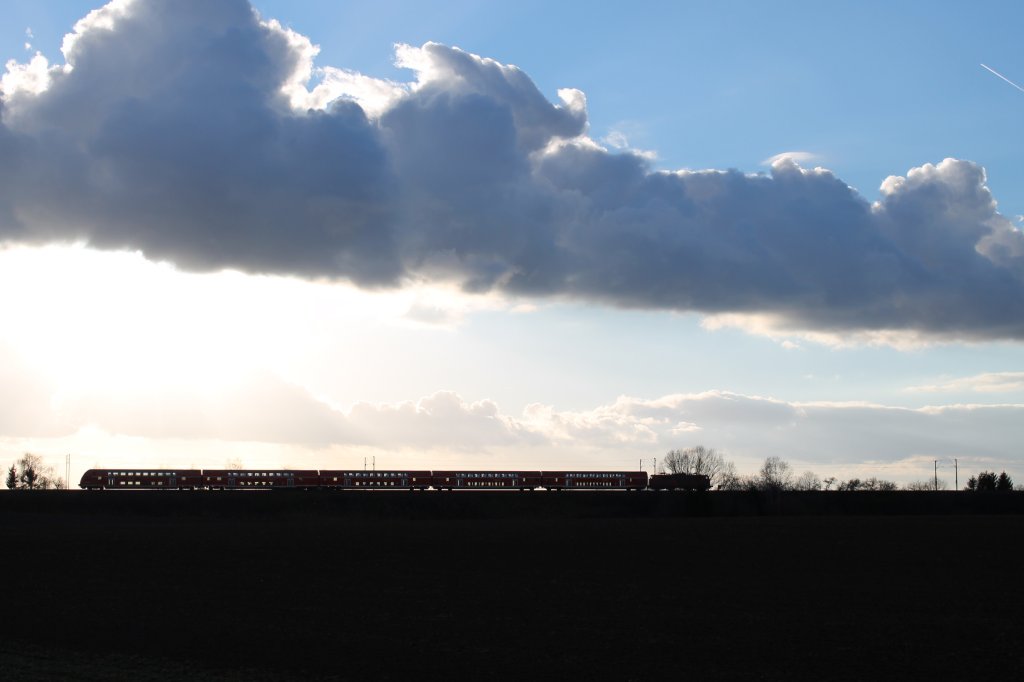 Am 02.01.2013 strebt eine unbekannt gebliebene 111 mit ihrem RE in Richtung Mnchen hier kurz vor Gaimersheim. Die schon sehr tief stehende Sonne scheint schon durch die Fensterscheiben der Wagen.