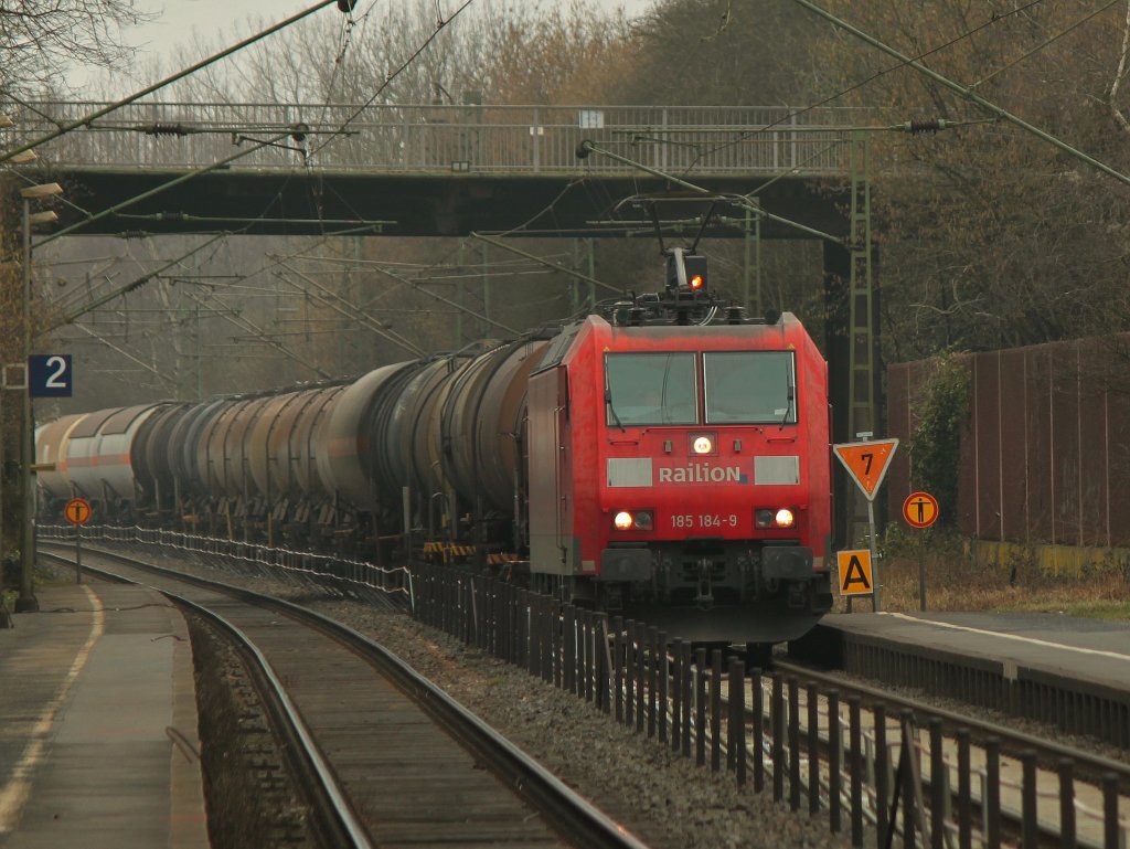 Am 03.03.2012 fhrt 185 184-9 auf der KBS 480 mit einem Kesselzug wegen der Baustelle ber Gleis 1 durch Eilendorf Richtung Kln.