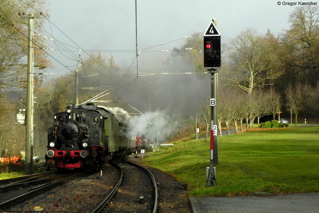 Am 03./04.12.2011 fanden die Nikolaussonderfahrten im Albtal statt. Nach dem Ausfall von beiden in Ettlingen West beheimateten Dampfloks musste eine Ersatzlok her. Das war eine mir leider unbekannte zweiachsige Tenderlokomotive. Am Zugende (nicht im Bild) leistete die AVG 461 (MaK G 1206) Schubhilfe. Das Bild entstand am 04.12.2011 in Etzenrot. Und genau in diesem Moment, als der Zug auftauchte, kam an diesem verregneten Tag die Sonne kurz raus.