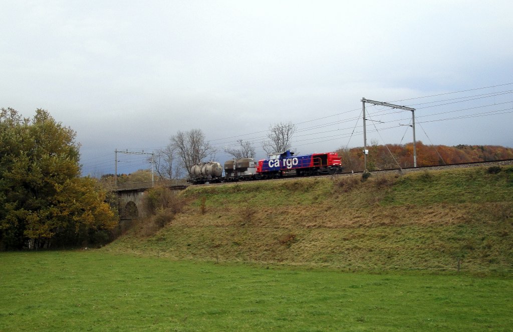 Am 05.11.2012 bringt die Am 843 078-1 zwei leere Zementwagen von Ddingen nach Fribourg und befindet sich seit wenigen Sekunden nach dem Passieren der Saine in der Romandie.