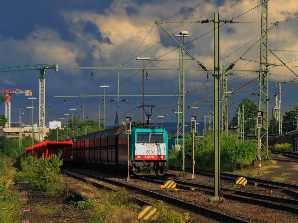 Am 06.08.2012 konnte ich das abendliche Licht in Aachen West mit den letzten Sonnenstrahlen vor dem dramatisch dunkel werdenden Himmel noch nutzen und ein Bild der Cobra 186 224 (2832) mit einem Kohlenzug am Haken machen. Dann ab ins Auto, denn kurz nach der Aufnahme regnete es wie aus Eimern. Rechts im Bild sieht man noch das Minarett der 1964 bis 1966 erbauten Bilal-Moschee des Islamischen Zentrums in Aachen.
