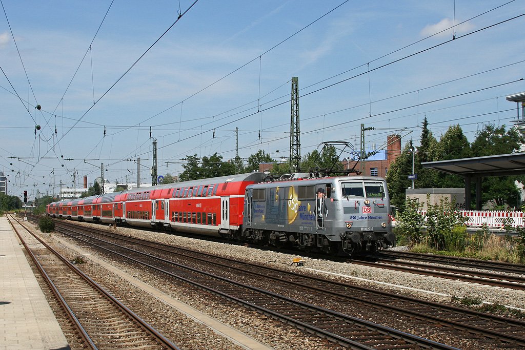 Am 07.08.2009 war 111 027 noch mit ihrer silbernen Beklebung unterwegs. Wie so oft war sie auch an diesem Tag zwischen M�nchen und Salzburg unterwegs, hier mit RB 30017 am Heimeranplatz. Auch in rot ist sie �brigens meistens wieder auf der Salzburger Strecke zu sehen.