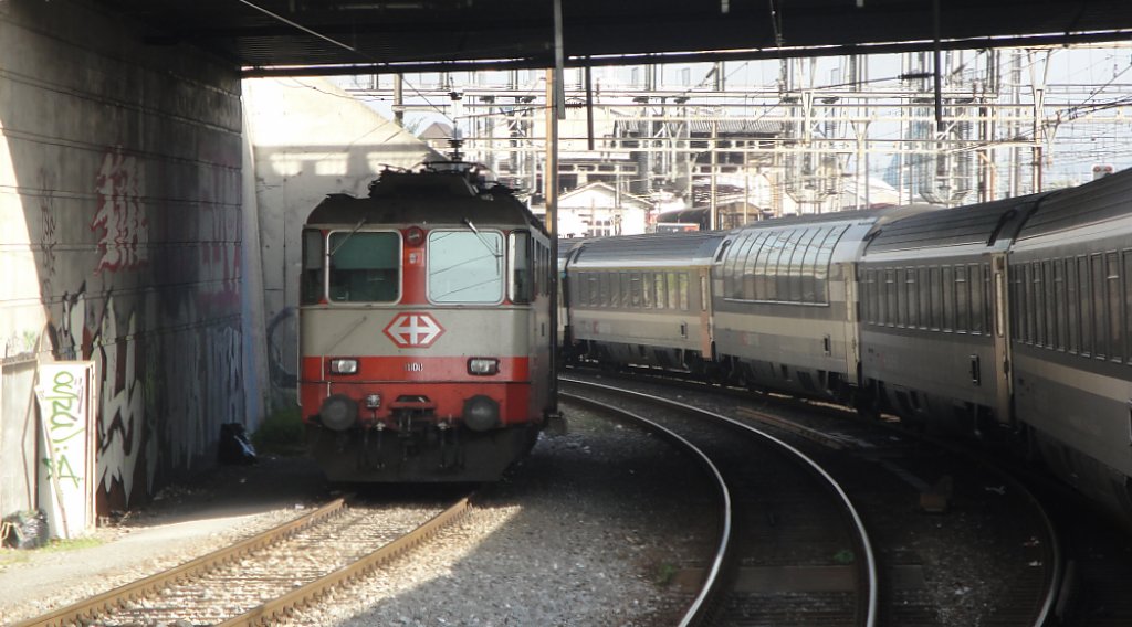 Am 08.10.10, um 16:05 als der IR nach Locarno soeben Basel SBB verlsst, steht die SwissExpress Re 4/4  11108 auf einem Abstellgleis unter der Brcke, nahe des GB Wolf.