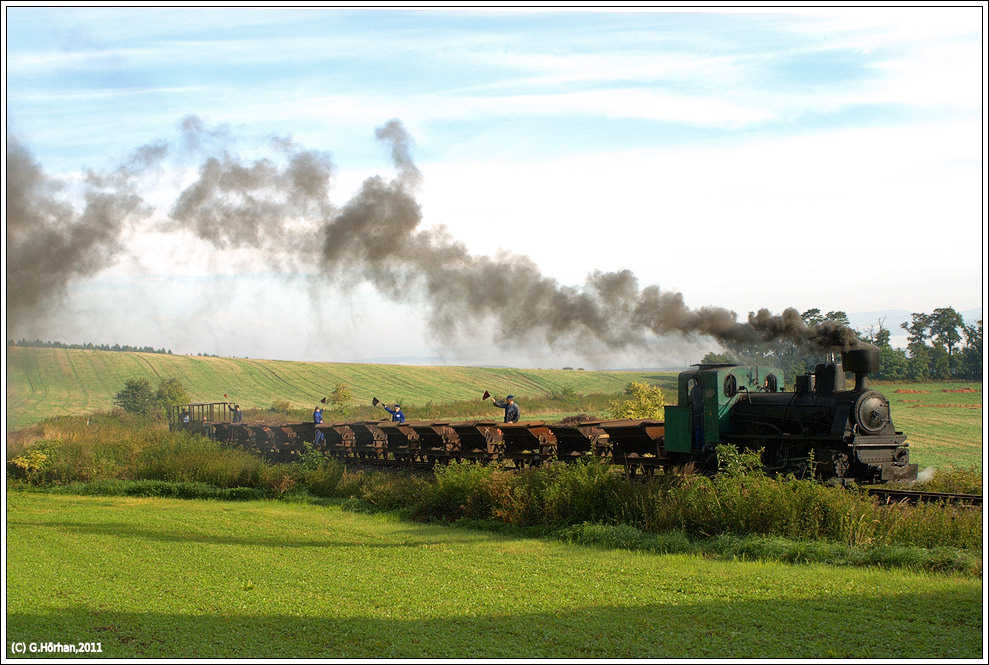 Am 10. und 11.9.2011 war ich in Tschechien bei einer Fotoveranstaltung an der Industriemuseumsbahn Mladejov na Morave. Diese Bahn fuhr von 1918 bis 1991 und befrderte Holz, Kohle und Chamotte-Ton. von den ursprnglich 6 Ct 1hv Sttztender-Loks sind noch zwei betriebsfhig, und zwar die Nr. 1 und die Nr. 5. Hier sehen wir die Lok 5  Petka  mit einer Lorengarnitur unweit des Betriebshofes Mladejov, nach dem die Strecke eine 180 Grad Kehre vollzogen hat.