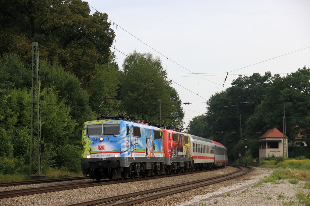 Am 11.08.12 wurden die DB-BB EuroCity Zugpaare 1289, 82, 89, 84 von einem Tandem der zwei Werbeloks 111 066  200 Jahre Biergarten - Ein Tag der bleibt  und 111 024  ADAC, DB - Fr Menschen unterwegs  bespannt.
Hier ziehen die beiden Loks den EC 1289 durch den Bahnhof Aling.