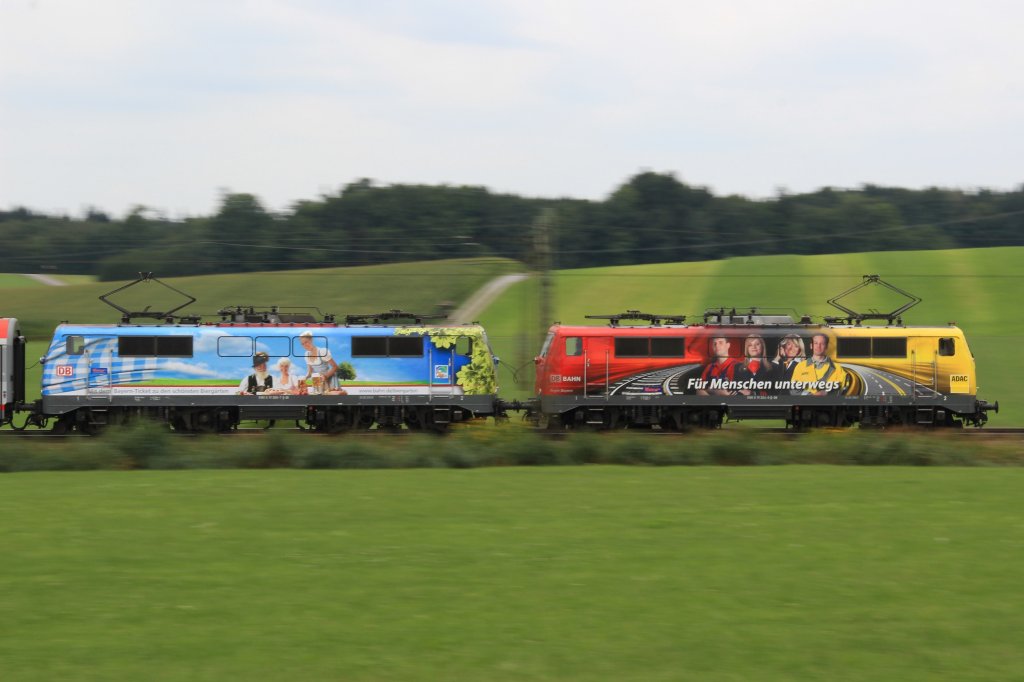 Am 11.08.12 wurden die DB-BB EuroCity Zugpaare 1289, 82, 89, 84 von einem Tandem der zwei Werbeloks 111 066  200 Jahre Biergarten - Ein Tag der bleibt  und 111 024  ADAC, DB - Fr Menschen unterwegs  bespannt.
Durch zeitweise schlechtes Wetter entschloss ich mich zu einem Mitzieher.
Hier ziehen die beiden Maschinen den EC 82. Aufgenommen bei Haus.
