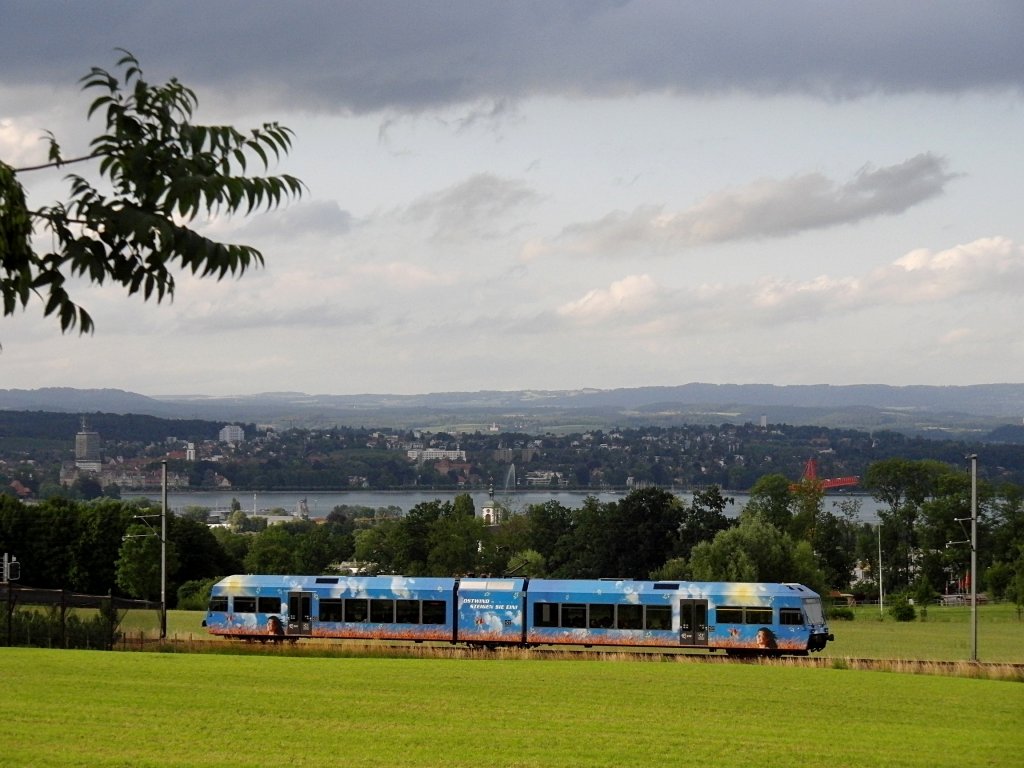 Am 18.06.2011 fhrt R 25879 von Konstanz nach Weinfelden zwischen Kreuzlingen-Bernrain und Lengwil den Seercken hinauf. In der Bildmitte im Hintergrund ist das sehr kleine, weie, auf dem Kopf stehende „T“ die Wallfahrtskirche Birnau. Kurz nach dem Regionalzug sollte eigentlich eine berfhrungsfahrt, bei der eine Re 4/4 eine dreiachsige Rangierlokomotive vom Typ Henschel DHG 700 C zieht vorbeikommen. Es dauerte aber etwas lnger und die am oberen Bildrand sichtbare dunkle Wolke hatte am Fotostandpunkt das letzte Abendlicht so stark abgeschwcht, dass das Foto von der berfhrungsfahrt zu dunkel wurde.