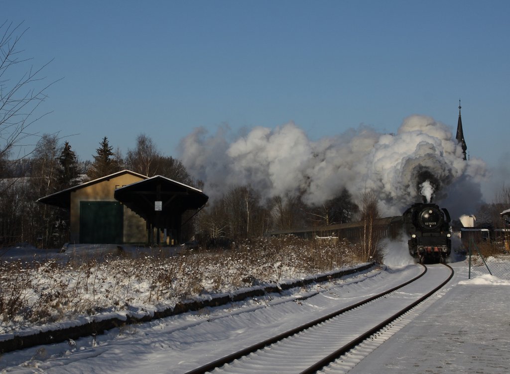 Am 20.12.09 passiert 65 1049 mit ihren Leerzug nach Crahnzahl den Haltepunkt Sehma. Leider verschwindet die Kirche hinter der Dampffahne.