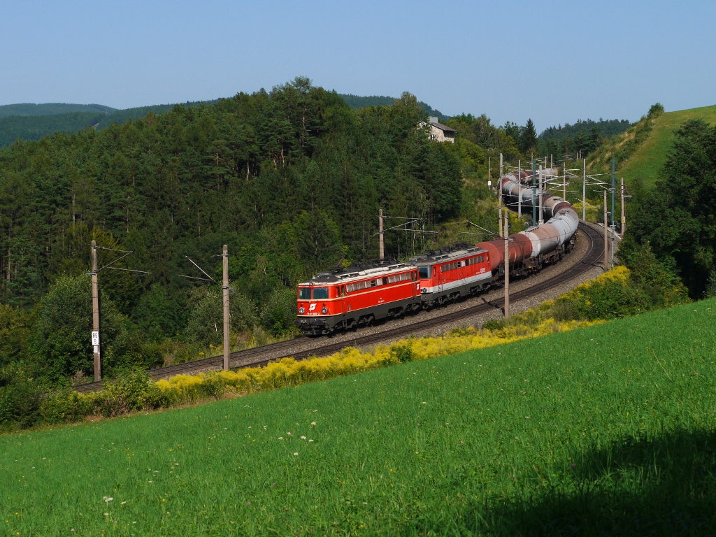 Am 23.08.12 waren BB 1142 682 und 1142 634 als Schubloks an den Zauberbergen eingeteilt.
Von der Steinbauer Wiese bei Eichberg wurde ihnen bei der Arbeit zugesehen.
Auf diesem Bild sieht man wie sie einen Kesselwagen-GAG nachschieben.