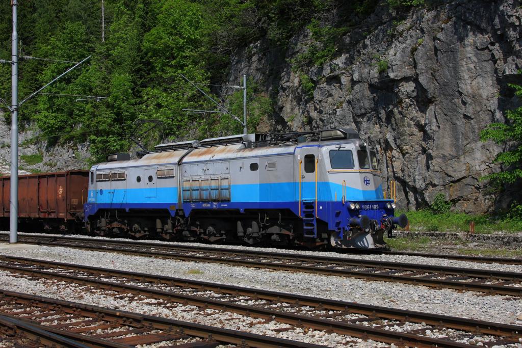Am 25.5.2011 war die Bergstrecke zwischen Rijeka und Ogulin hier im
Bahnhof Lokvet noch fest in Hnden der HZ Altbau Lokomotiven der Reihe 
1061. Diese schweren sechsachsigen Gelenklokomotiven zogen damals die
schweren Zge ber die Bergstrecke. Im Bahnhof Lokvet gab es dabei hufig
eine Zugkreuzung und Gterzge, wie hier die 1061.109, die gerade mit einem
Gterzug nach Rijeka unterwegs ist und im Ausweichgleis einen Gegenzug
abwarten muss.