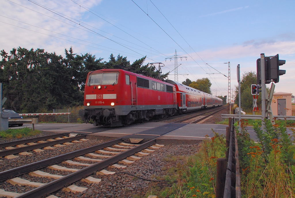 Am 27.8.2012 ist die 111 015-4 die Zuglok des RE4 Zuges von Dortmund nach Aachen und ist hier am Bahnbergang Herrather Linde zu sehen.