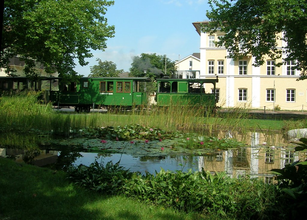 Am 28.08.2009 fhrt die Tramwaylokomotive mit ihrem Zug in Richtung Prien Stock an diesem kleinen Park mit Teich vorbei.